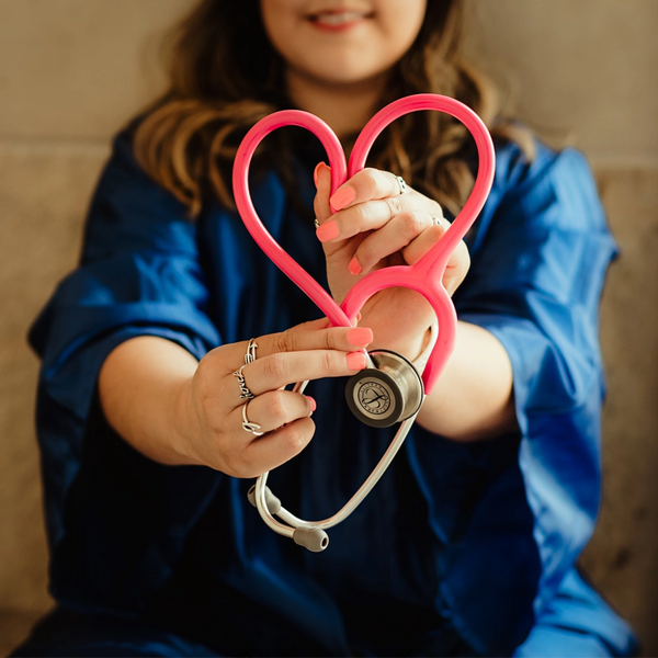 Healthcare professional holding a heart-shaped stethoscope symbolizing compassionate care